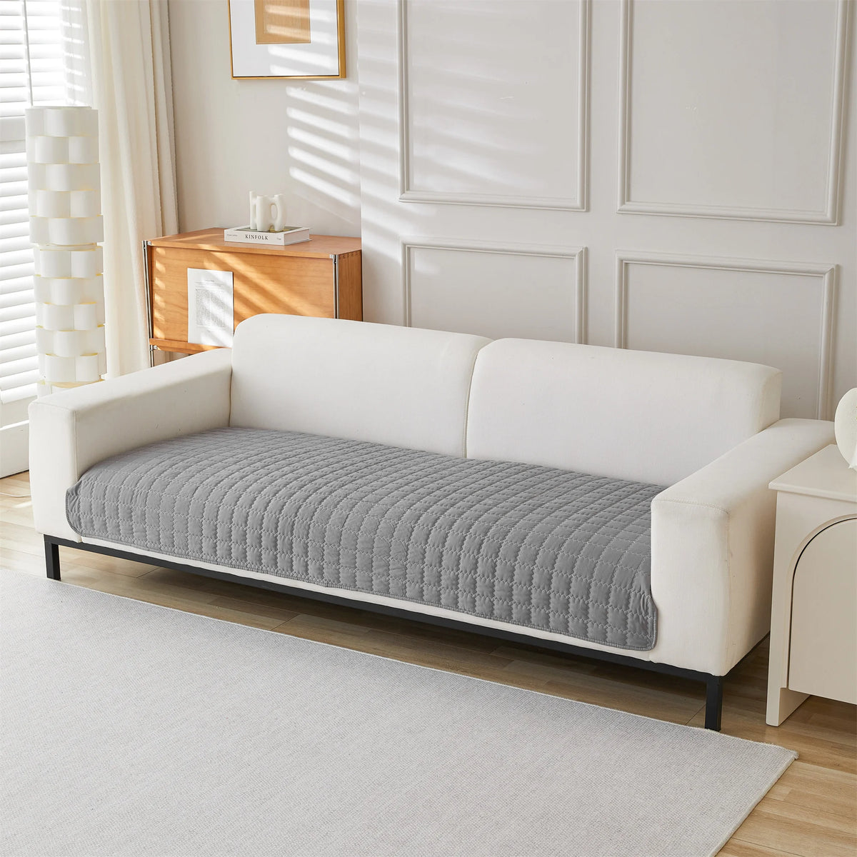 Light grey quilted panel covering a sofa seat