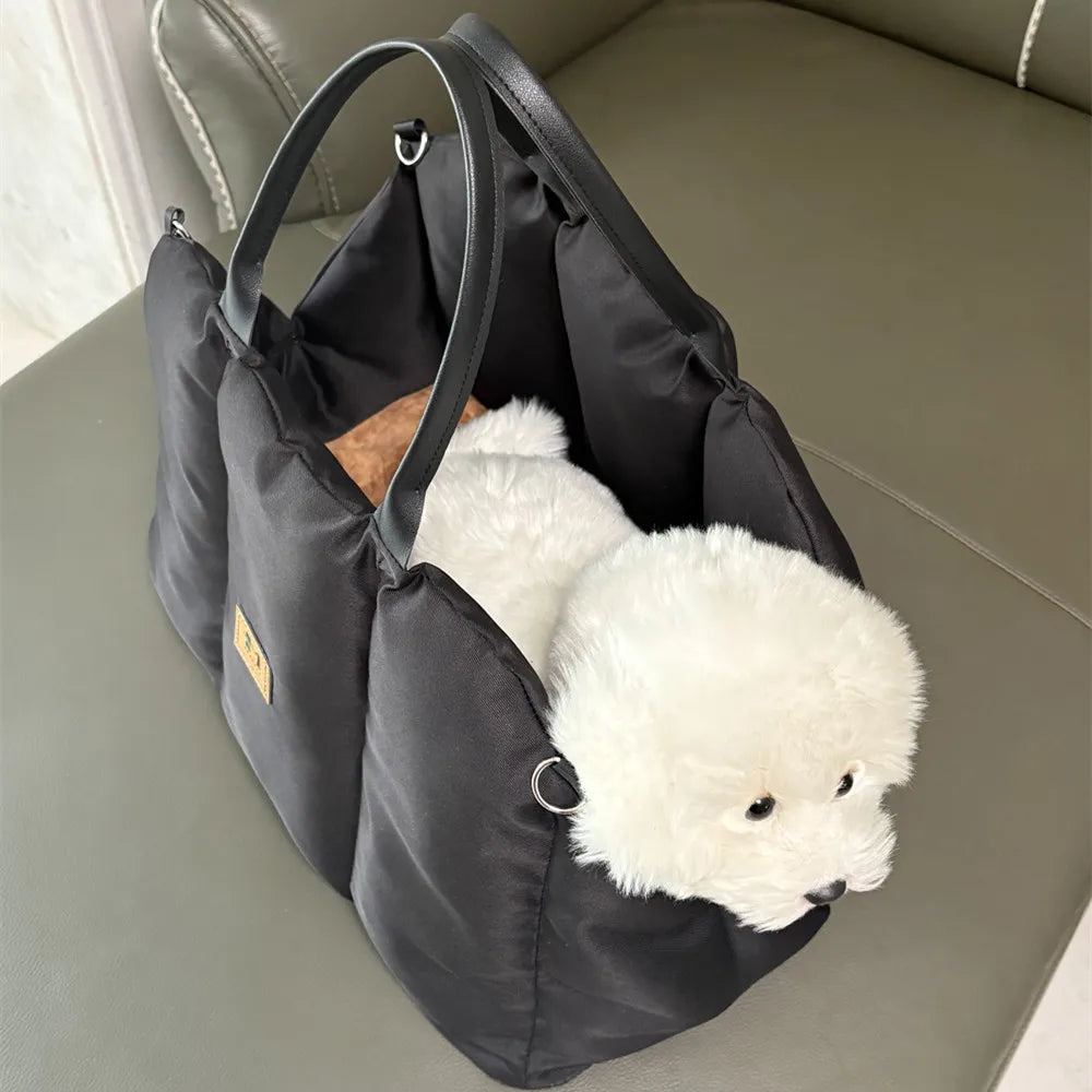 Small white dog resting inside the black Convertible Nest pet carrier
