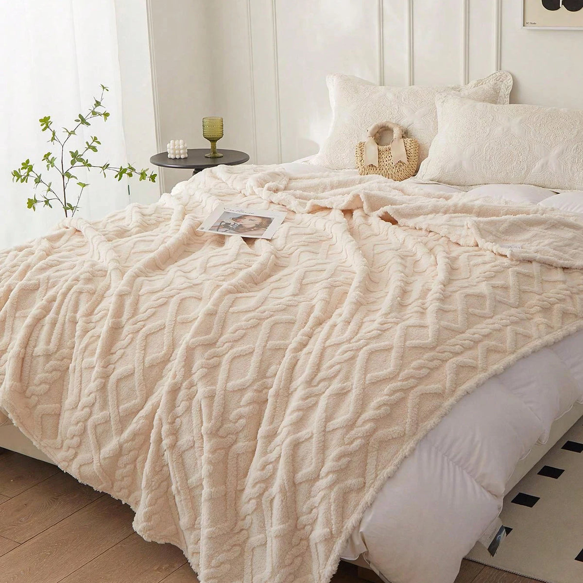 Cream Featherweight Throw layered across the foot of a bed.